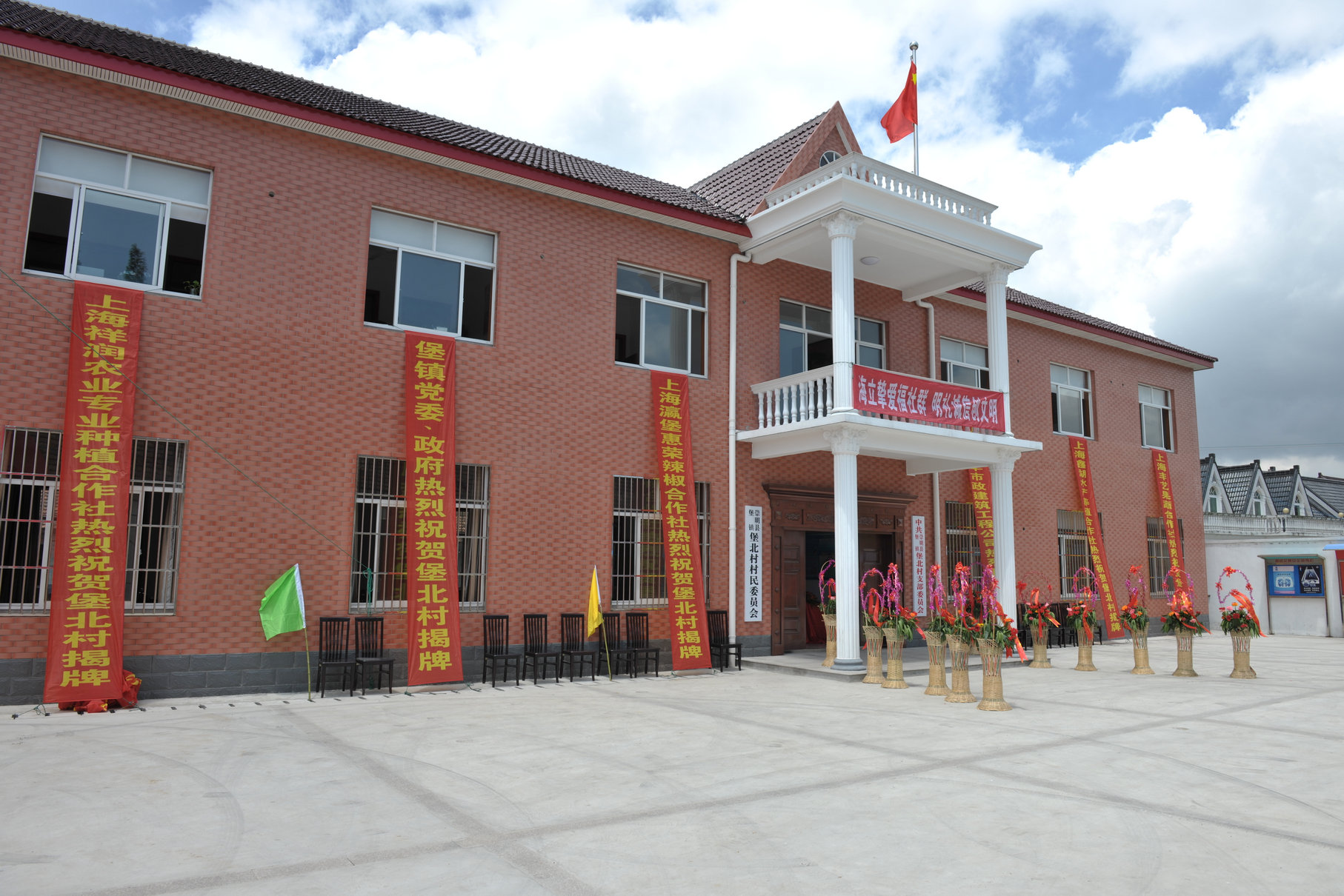 云顶国际版对口援建的崇明堡北村“为农综合楼”竣工举行揭牌仪式